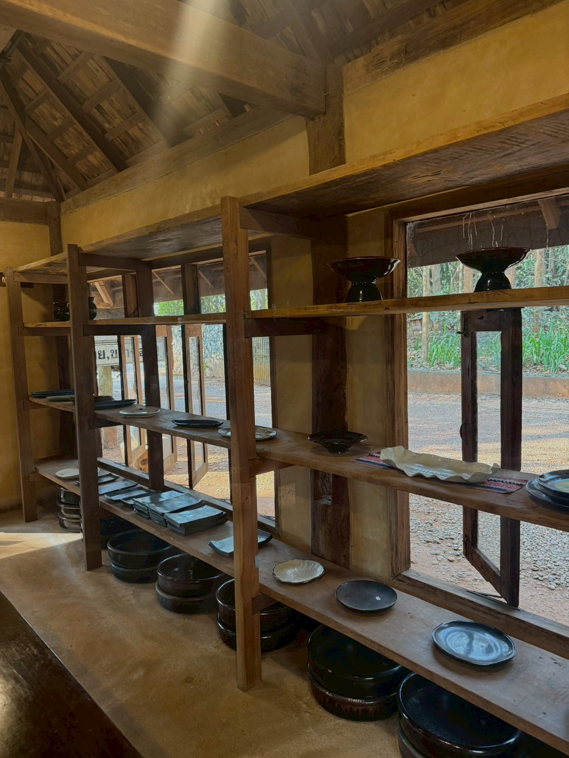Dark ceramics shelf by the open window
